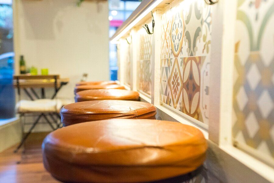 Barra con taburetes de madera y azulejos hidráulicos