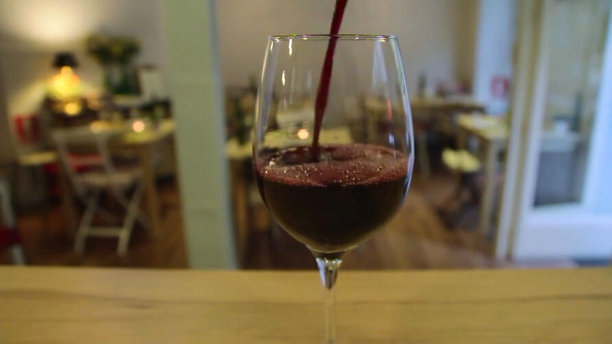 Copa de vino tinto sirviéndose en la sala del restaurante