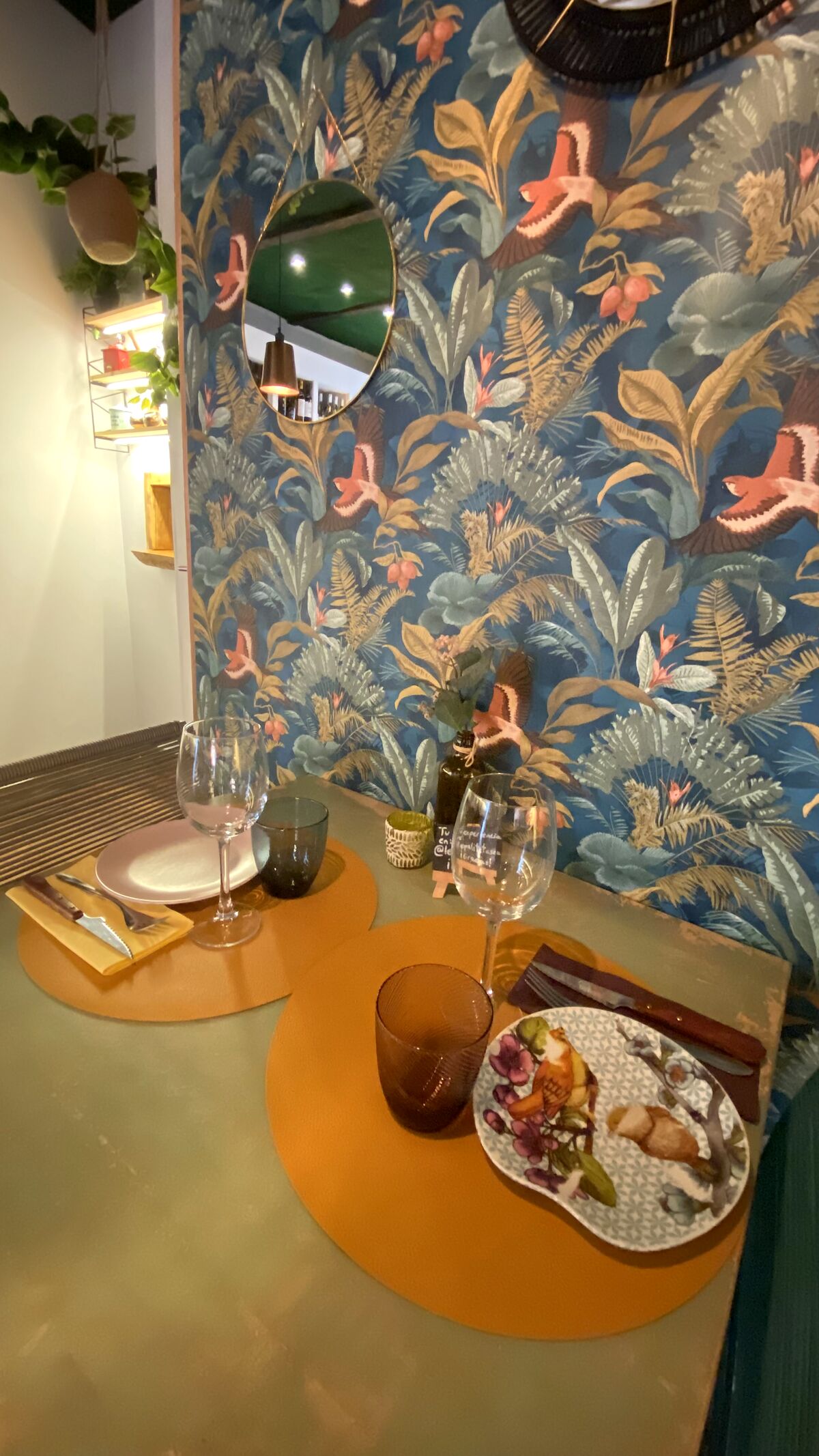 Mesa preparada junto a la pared empapelada con motivos botánicos